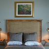 "Live Oak" Bedroom.  Live Oak headboard with some rough edges left to foil the smooth, waxed surfaces of the rest of headboard.  Headboard is upholstered with padded sisal rug section.  Live Oak cantilevered nightstands to match.  Framed photo over bed by Christopher John.