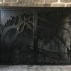 A custom made fireplace screen with two doors.  Design was plasma cut out of a single sheet of 3/16" steel.  Design is of Live Oak trees in front of a winding creek with an old dock, Clemson flag, and seagulls.
