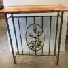 Console table (36"H, 32"W, 14"D) with hand wrought daylily panel, distressed wrought iron base.